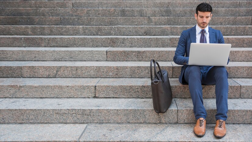 Man using a laptop on steps, symbolizing business planning and strategy.