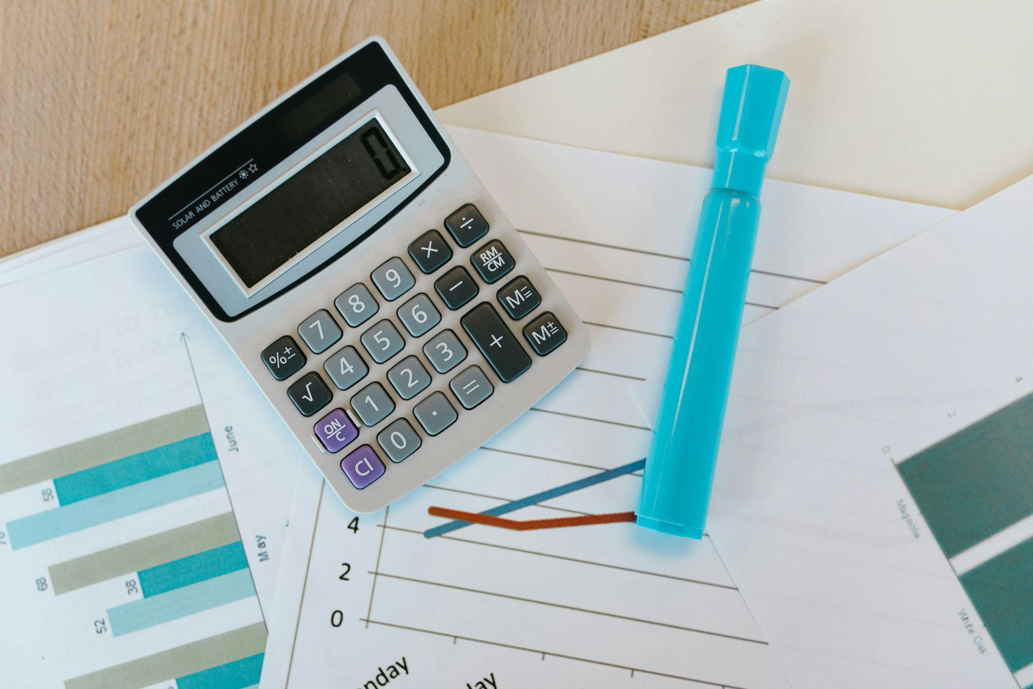 Sharpie and calculator placed on a table for financial calculations.