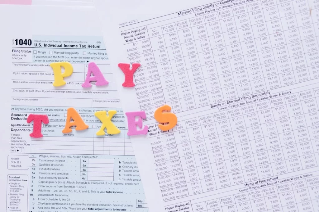 Colorful letters spelling out PAY TAXES placed on a tax form