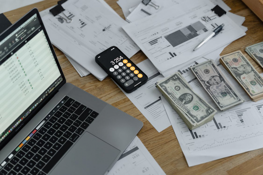 dollar bills placed next to an open laptop